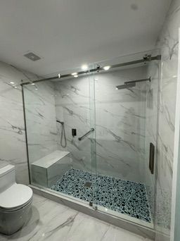 Glass sliding shower with a built-in bench and pebble floor