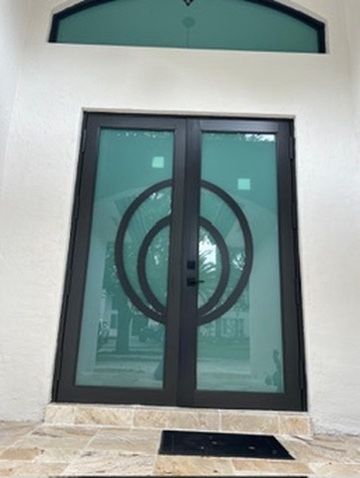 Double entry door with a circle design and tinted glass