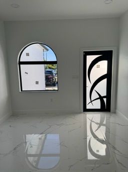 Inside view of an arched window and an iron entry door