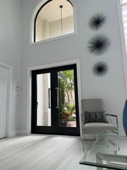Double doors in a tall entry with a transom window