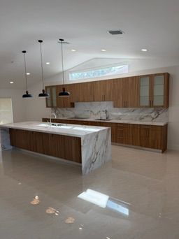 Kitchen with walnut-tone cabinets and a marble waterfall island