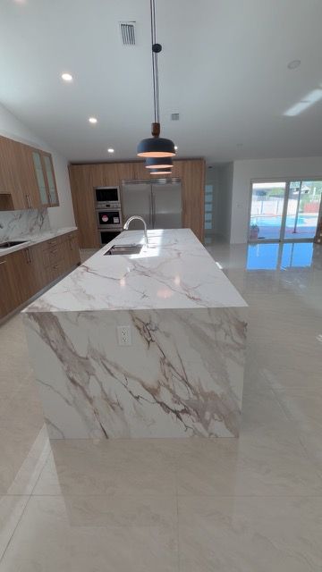 Marble-look waterfall island in a bright open kitchen