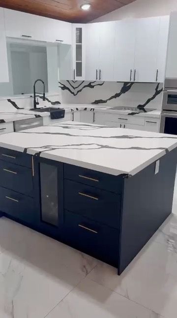 Navy blue island with a black-veined quartz countertop