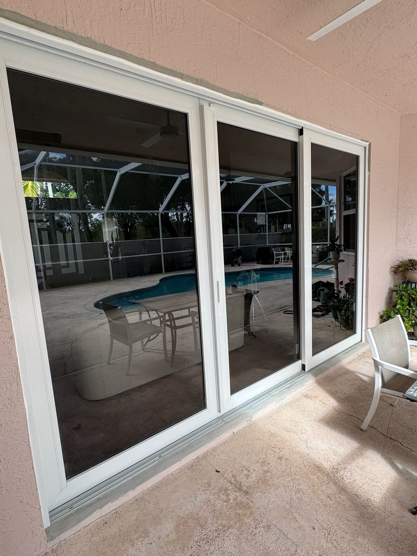 Three-panel sliding glass door opening to a screened pool