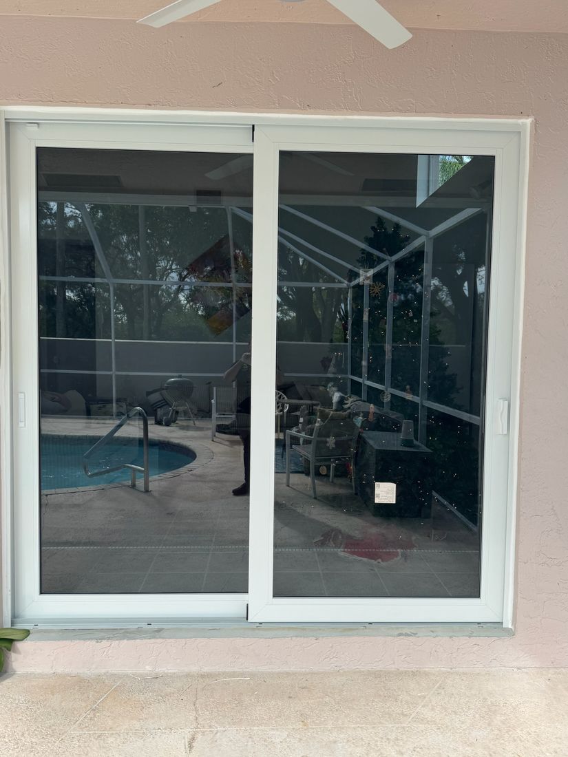 White two-panel sliding door with a view of the pool