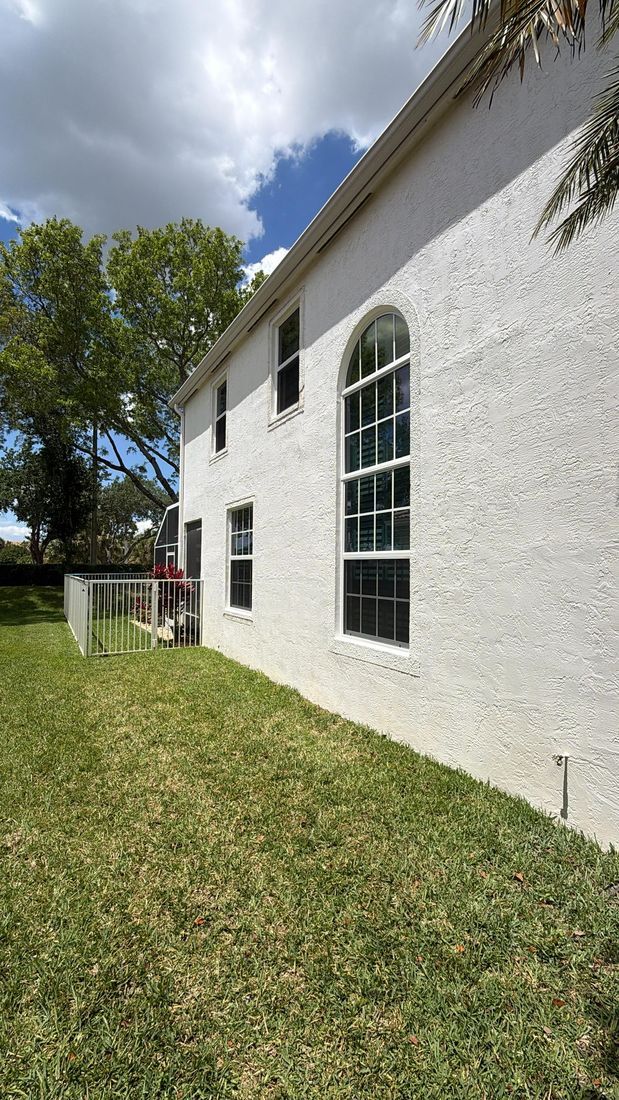 Arched window on the side of a white two-story house